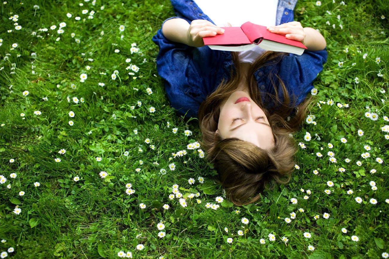 A girl is reading a book in spring