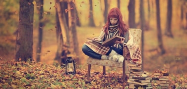 A girl reading a book in autumn