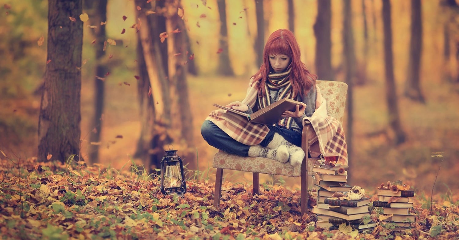 A girl reading a book in autumn