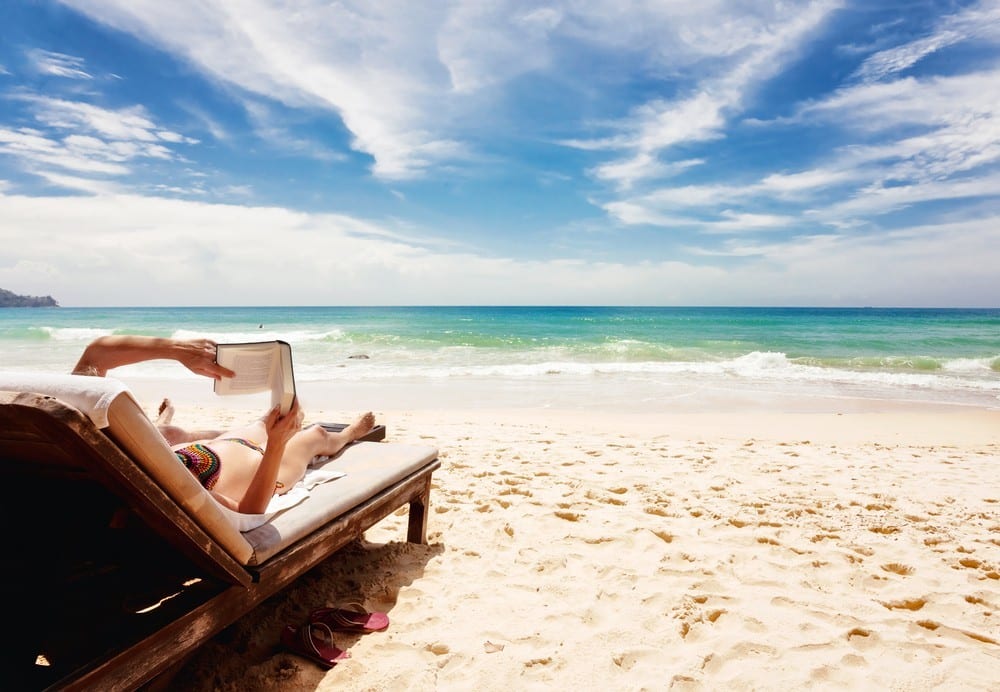 Woman reading a book on a beach