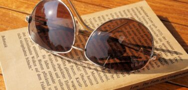 Sunglasses on closed book in warm sunshine