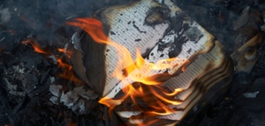 A banned book being burned in a fire