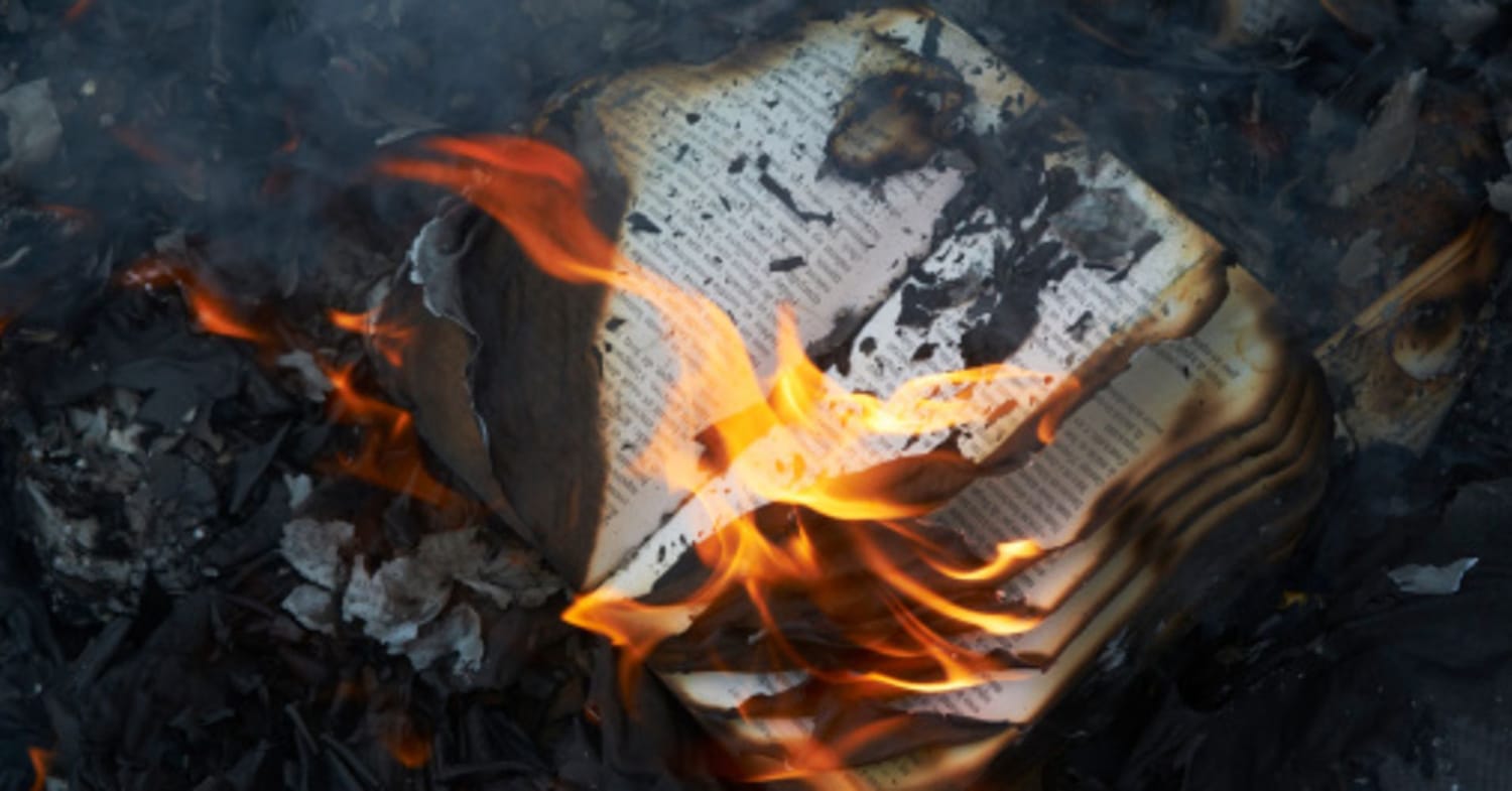 A banned book being burned in a fire